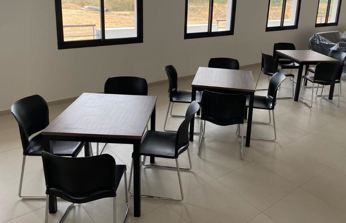 A classroom featuring several tables and chairs arranged neatly throughout the area