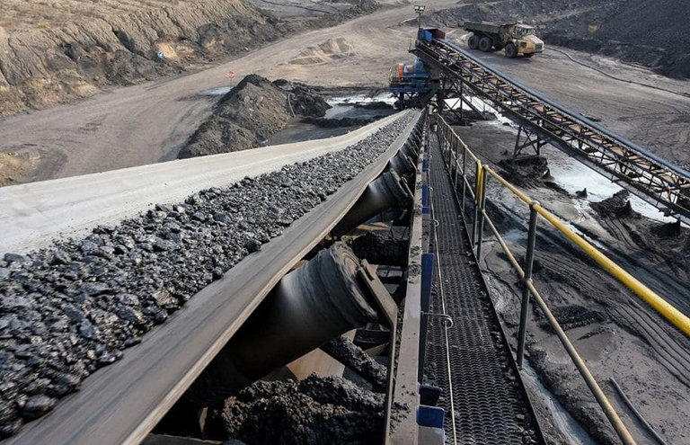 A conveyor belt transports coal from a mine to a processing area